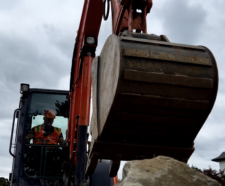 Paradise Landscaping Founder operating a back-hole.